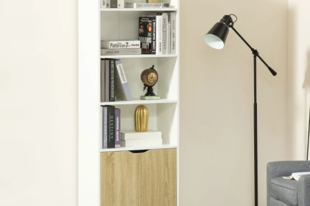 White bookshelf with books and décor beside floor lamp in modern living room.