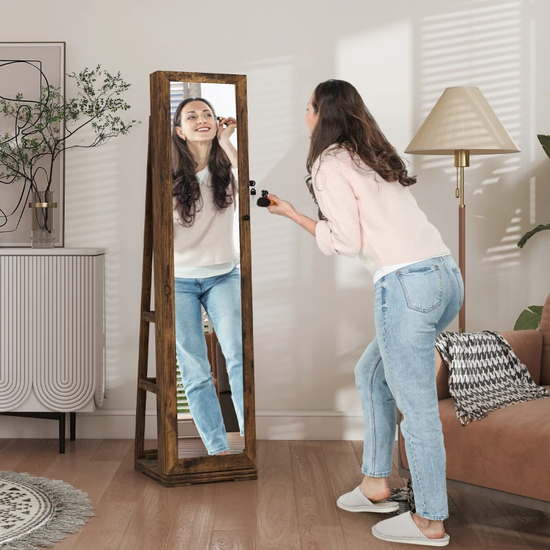 Wooden standing mirrored jewelry armoire with woman applying makeup, placed in bright stylish living room.