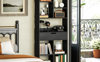 Black modern bookshelf beside bed near balcony, filled with books and décor accessories.