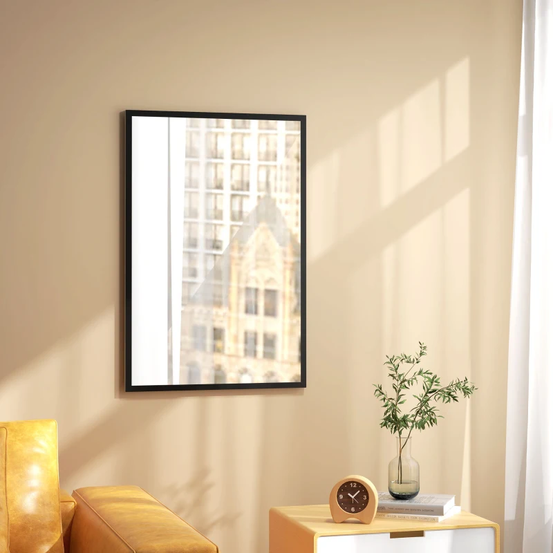 Rectangular decorative wall mirror with black frame reflecting city view beside yellow armchair.