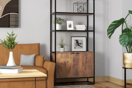Modern bookshelf styled with books, plants, and framed art in cozy living room.
