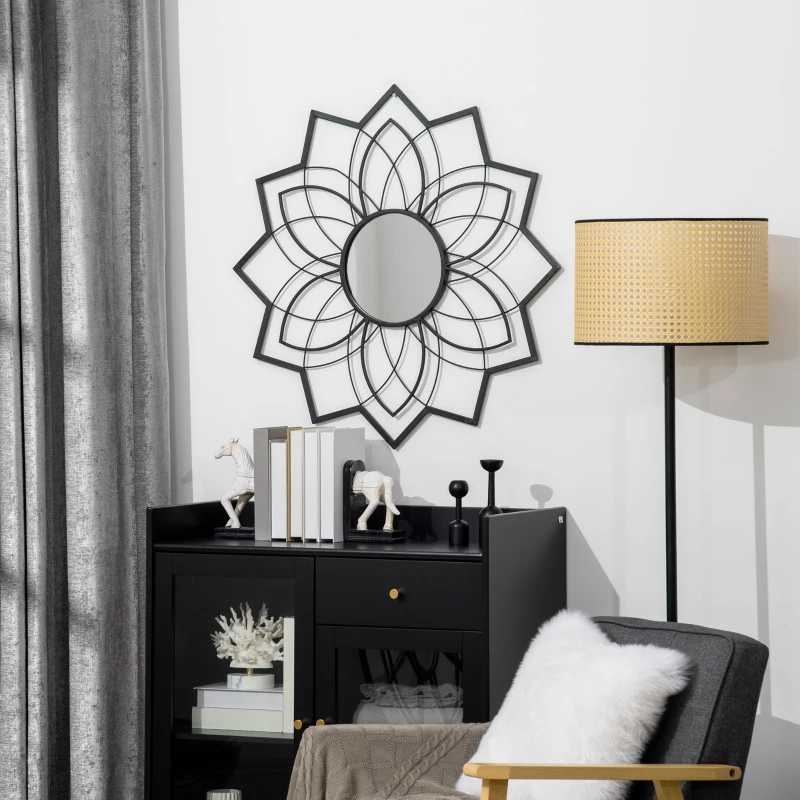 Decorative flower-shaped sunburst mirror with black frame hanging above cabinet in a modern living room.