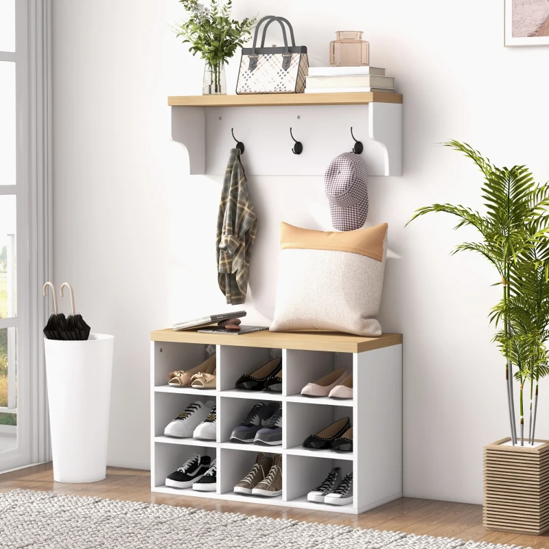 White entryway bench with shoe storage, hooks for coats, and shelf with plants and bags.