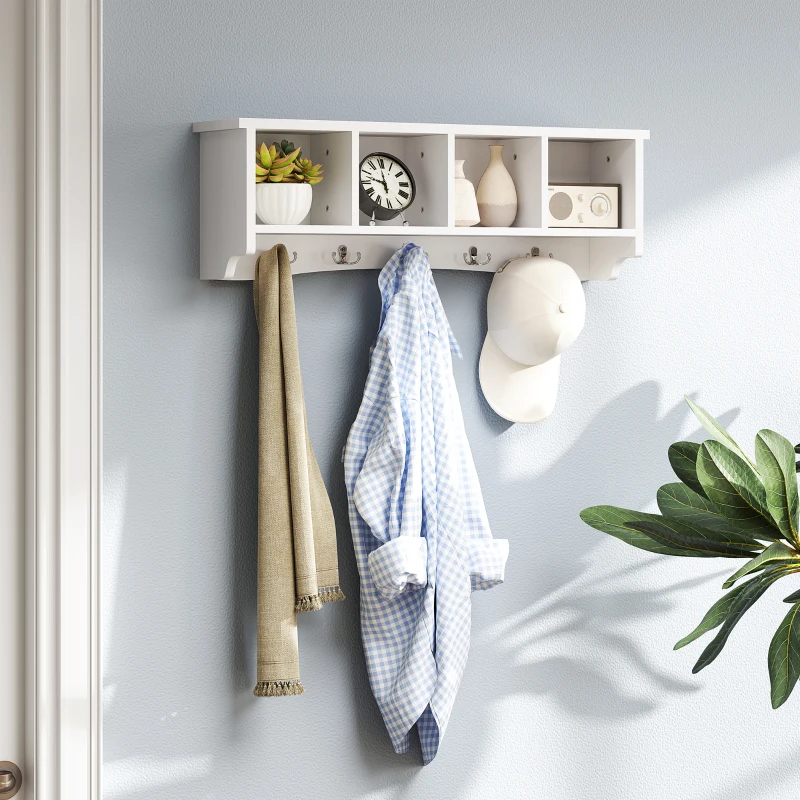  White wall-mounted coat rack with small cubby shelves holding clothes, hat, and decorative items.
