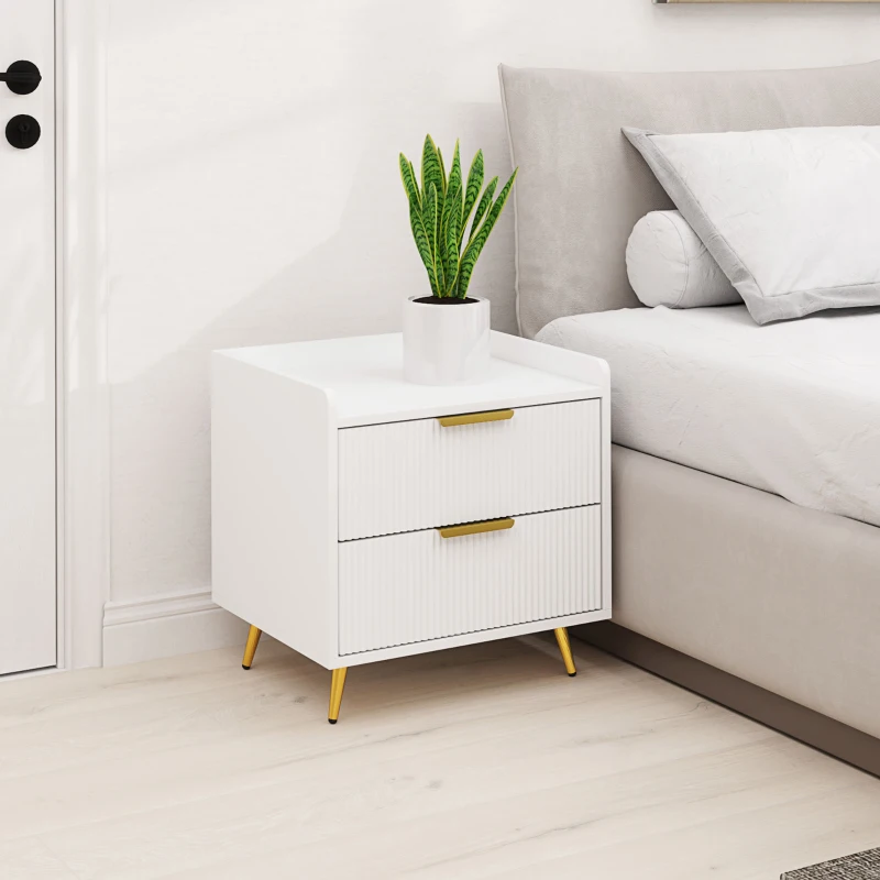White modern bedside table with gold handles and legs, styled with green potted plant on top.