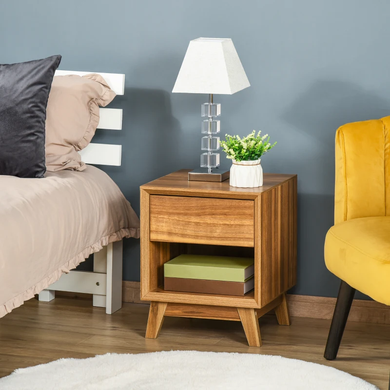 Wooden bedside table with drawer, open shelf, modern lamp, and decorative plant beside bed.