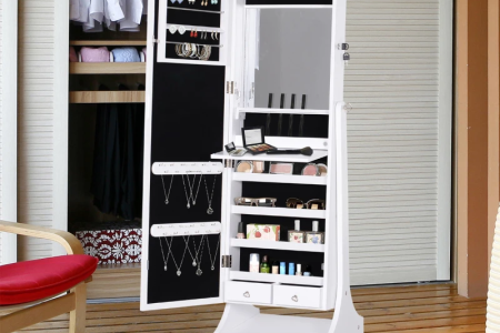 Standing white armoire open, showing shelves with jewelry, makeup, accessories, and mirror.