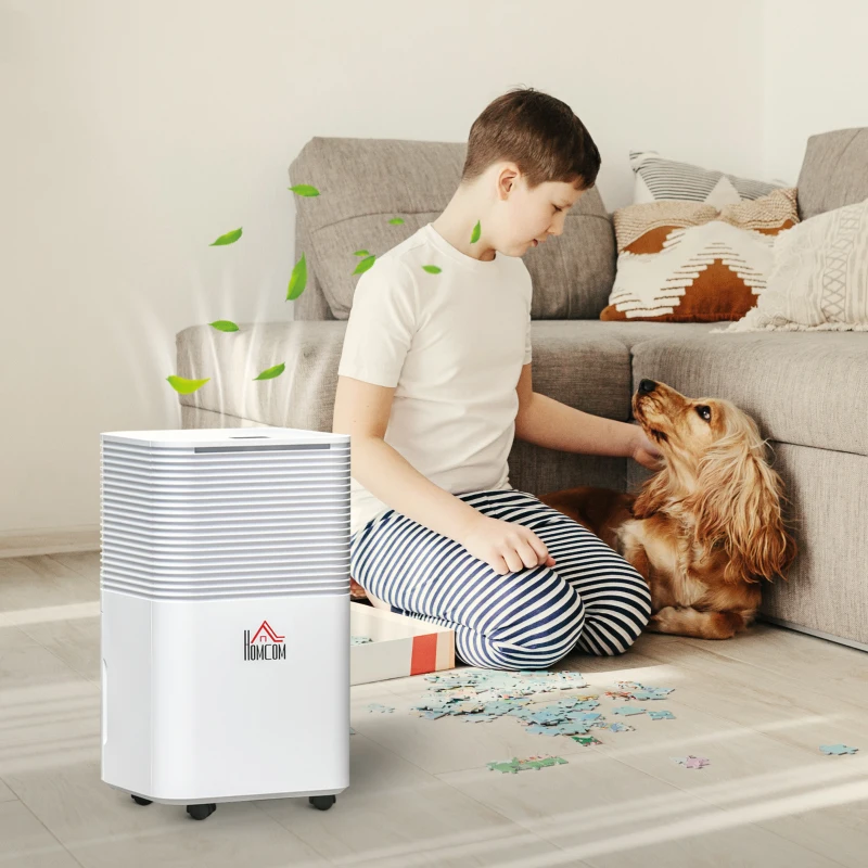 Small portable dehumidifier beside boy and dog indoors.
