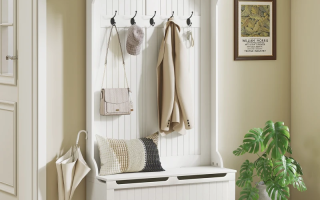 White hall tree with coat, bag, umbrella, cushion, and shelf décor in entryway.