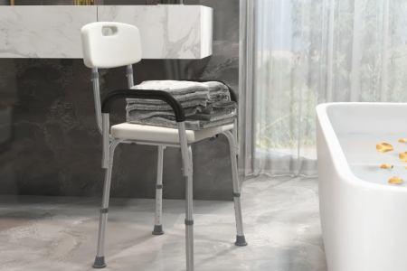 Rolling shower wheelchair placed next to a bed.