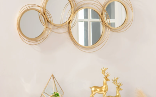 Gold circular metal wall art mirror above console with décor