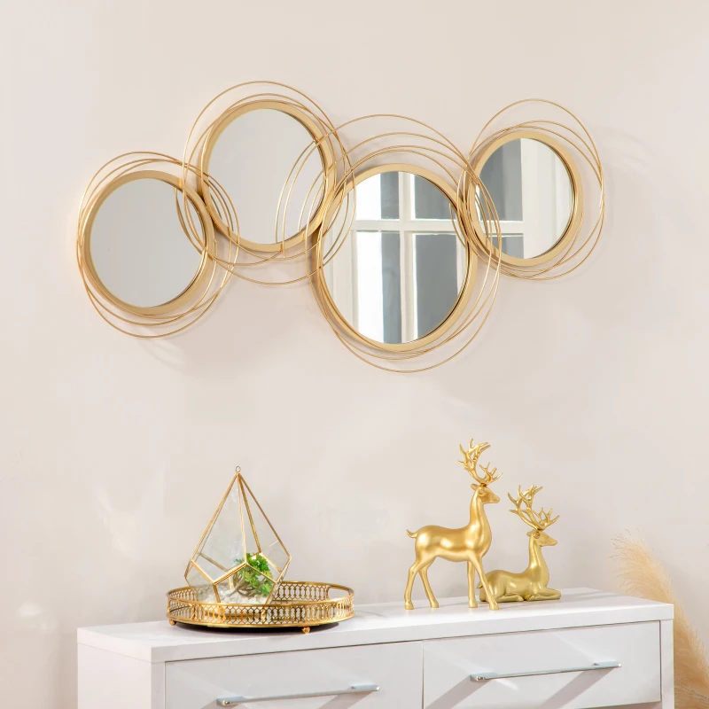 Gold circular metal wall art mirror above console with décor