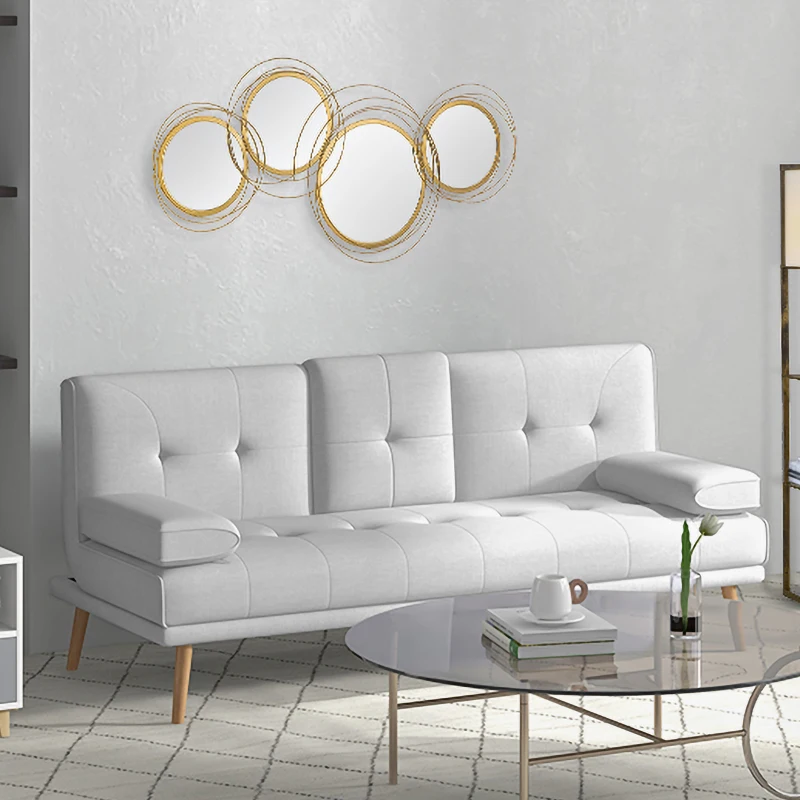 Gold metal wall art mirror mounted above white modern sofa