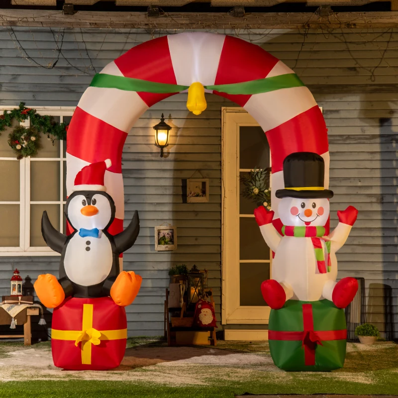 Inflatable archway with penguin and snowman sitting on gift boxes.
