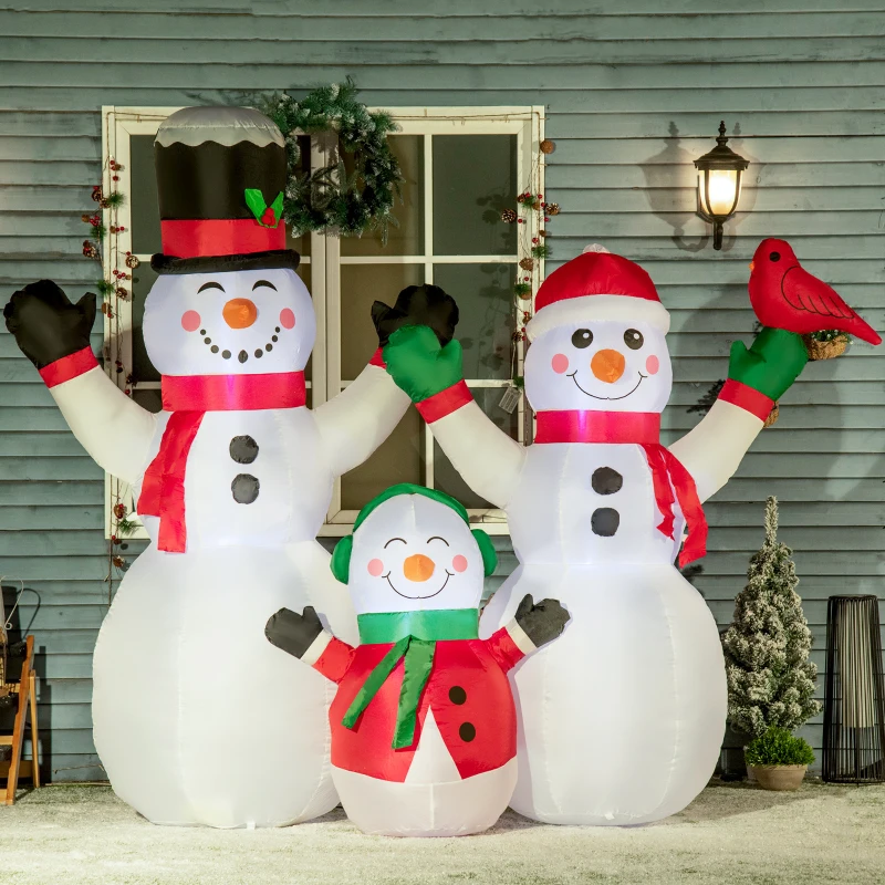 Inflatable snowman family with red scarves and hats outside home.