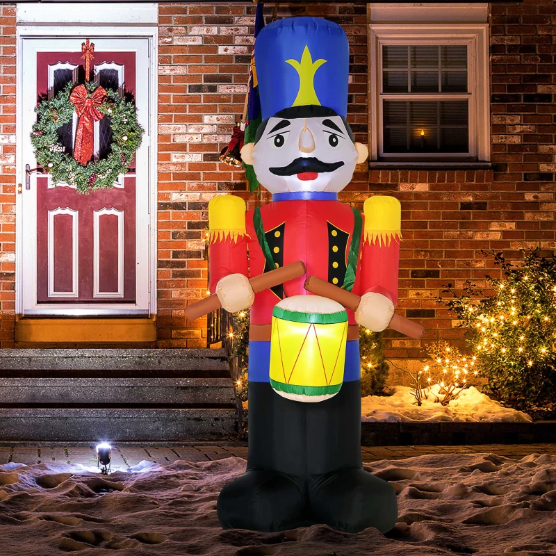 Inflatable nutcracker soldier with drum standing at decorated house entrance.