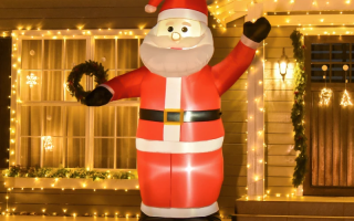 Large inflatable Santa glowing outdoors with festive house lights.