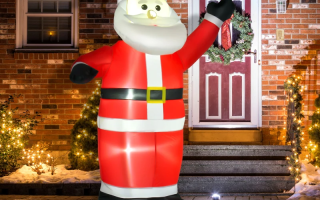Inflatable Santa glowing outdoors with Christmas lights at night.