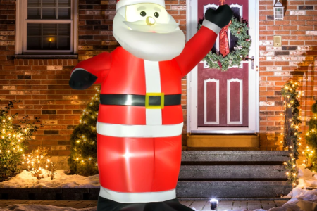Inflatable Santa glowing outdoors with Christmas lights at night.