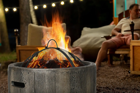 Stone fire pit burning brightly with chairs placed around