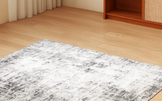 Grey and white area rug laid flat on light wood flooring in a tidy, minimal living room.