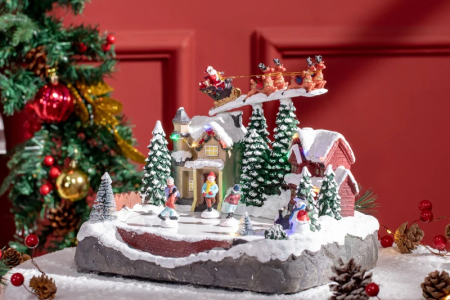 Festive Christmas village display with Santa sleigh and snowy trees.