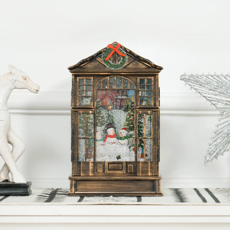 Vintage-style Christmas snow globe house with snowmen scene inside.