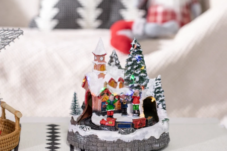 Snowy Christmas village with skaters, Santa sleigh, houses, and lights.