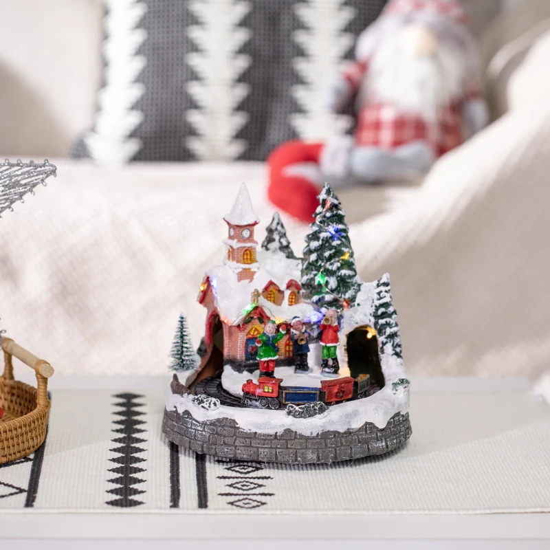Snowy Christmas village with skaters, Santa sleigh, houses, and lights.