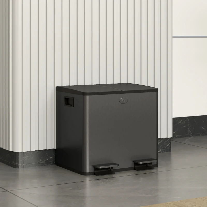 Black dual-pedal garbage bin placed neatly against a wall.