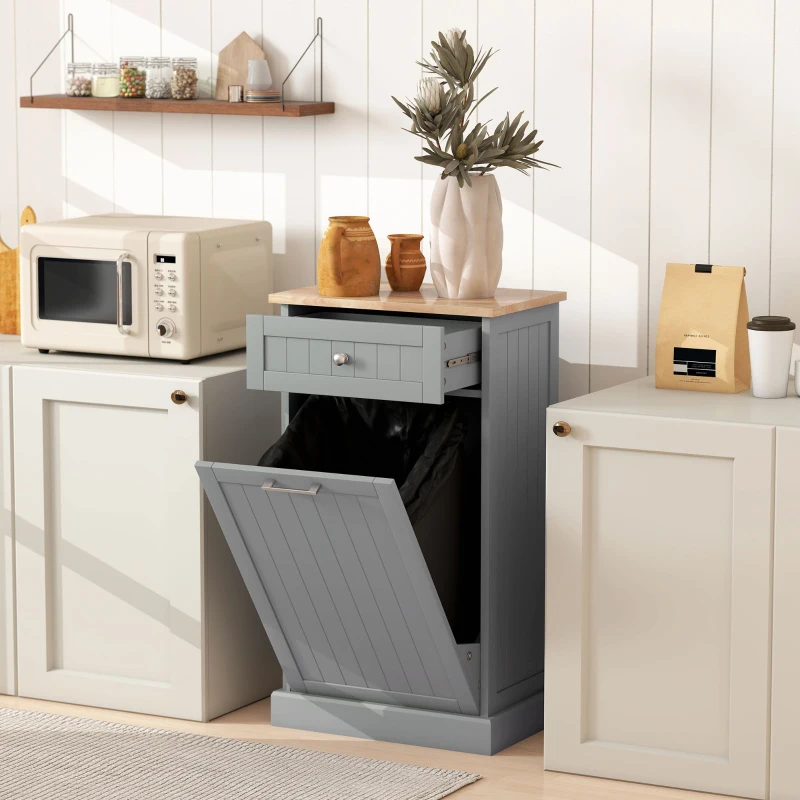 Gray wooden tilt-out trash bin cabinet with drawer in kitchen.