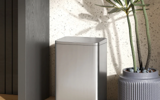 Modern stainless steel trash bin beside indoor plant.