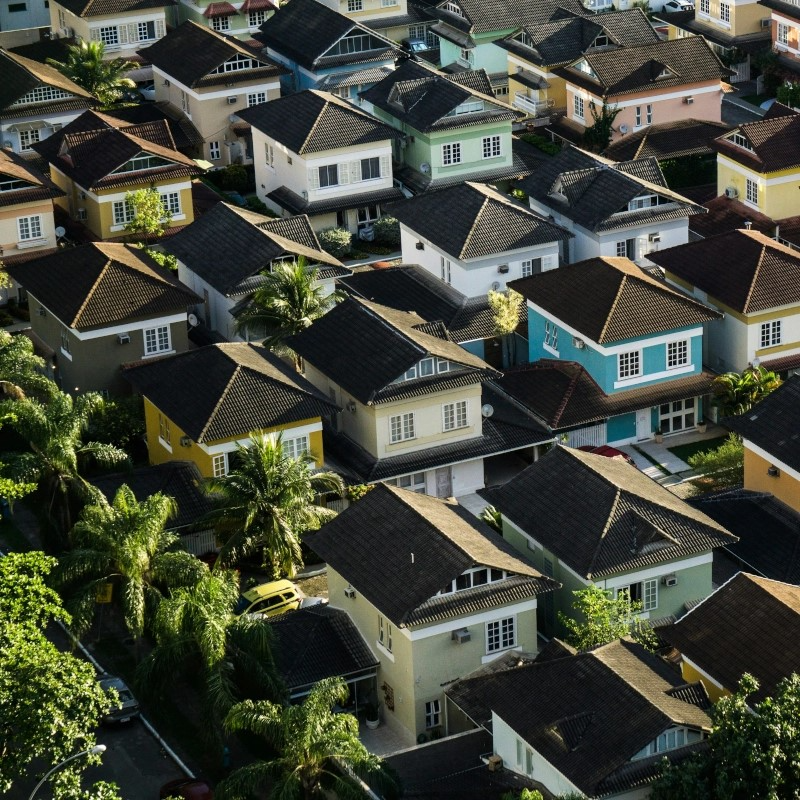 Aerial view of residential neighborhood with rows of houses and tiled roofs.