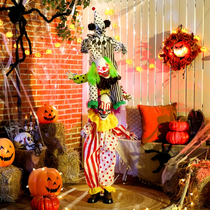 Creepy clown decorations stacked with pumpkins, cobwebs, and glowing lights in a spooky Halloween setup.