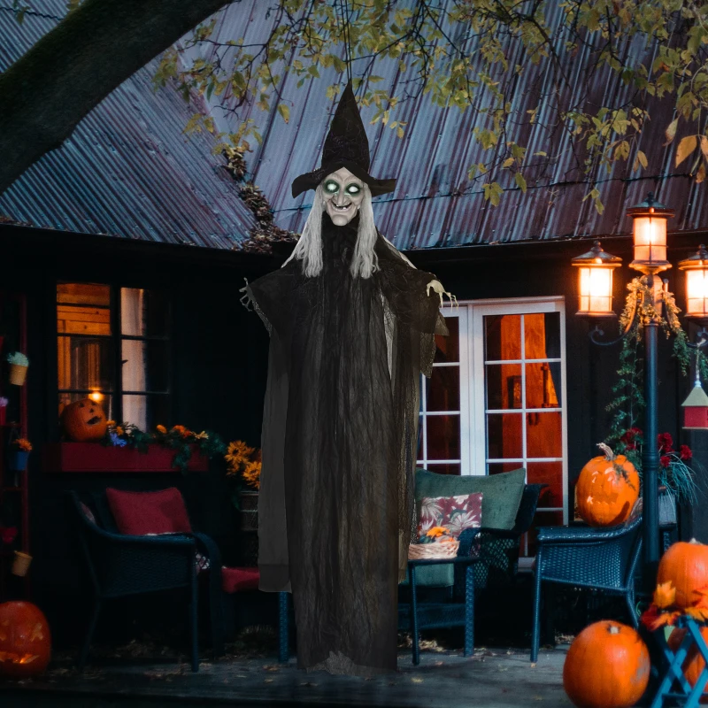 Tall witch with glowing green eyes set among pumpkins outdoors.