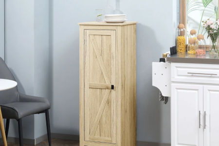 Fully assembled farmhouse kitchen pantry cabinet with barn-style door placed in a modern kitchen setup.