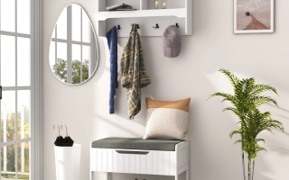 White hall tree with hooks, storage bench, mirror, and indoor plant in bright entryway.