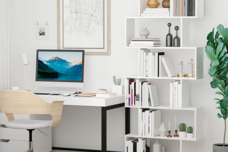 White S-shaped wooden bookcase styled with books and modern décor.