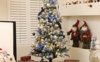 Flocked Christmas tree with blue ornaments and gifts beneath