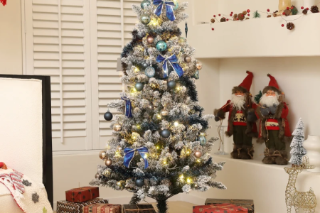 Flocked Christmas tree with blue ornaments and gifts beneath
