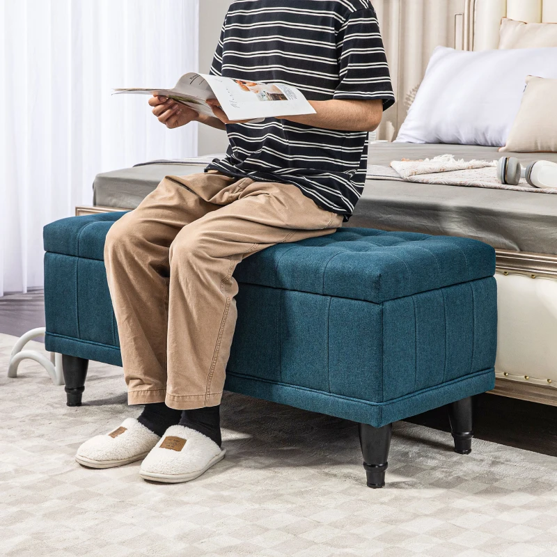 Blue linen storage ottoman at bed foot in cozy bedroom