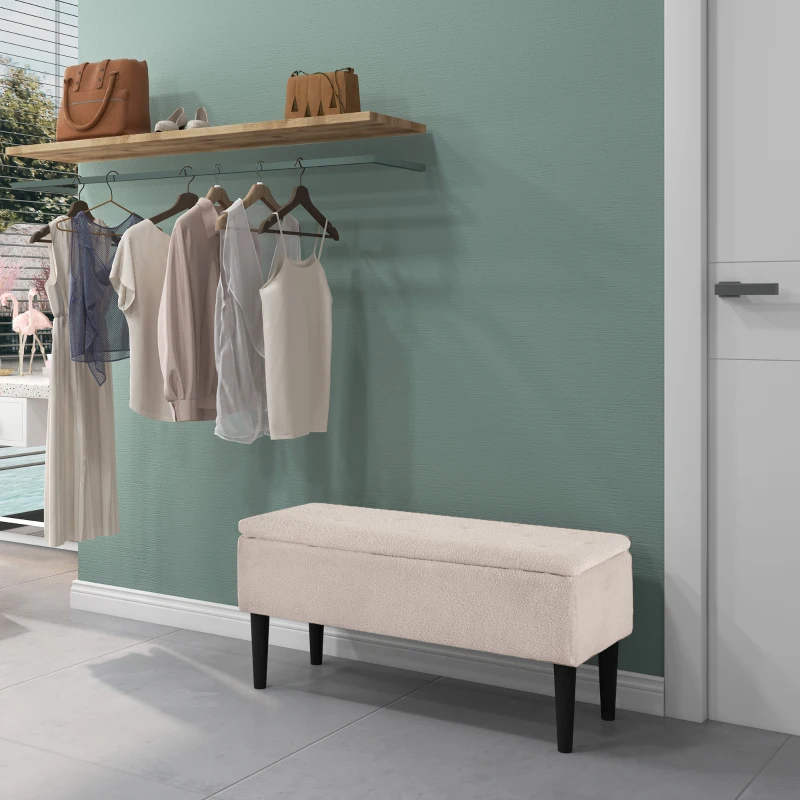 Cream wool storage bench beside clothing rack in modern entryway
