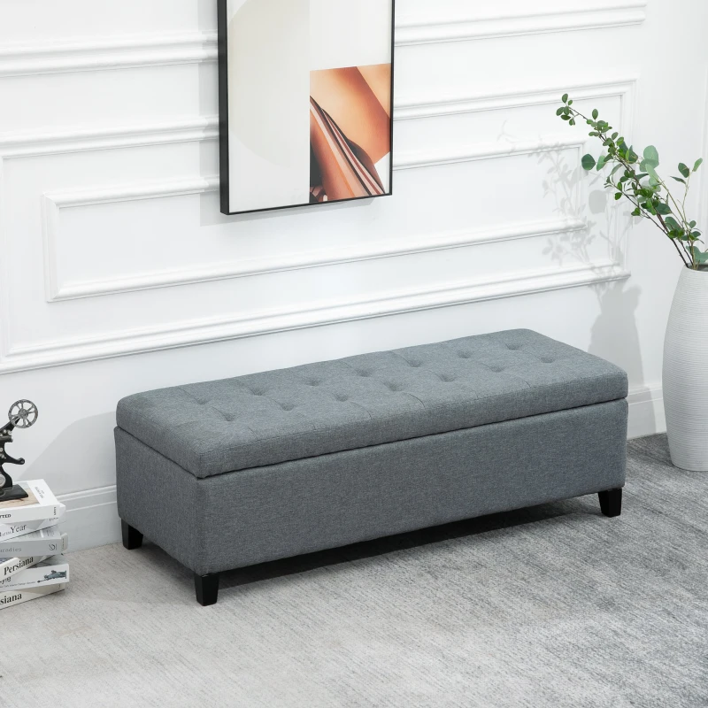 Grey tufted fabric bench with modern wall art above