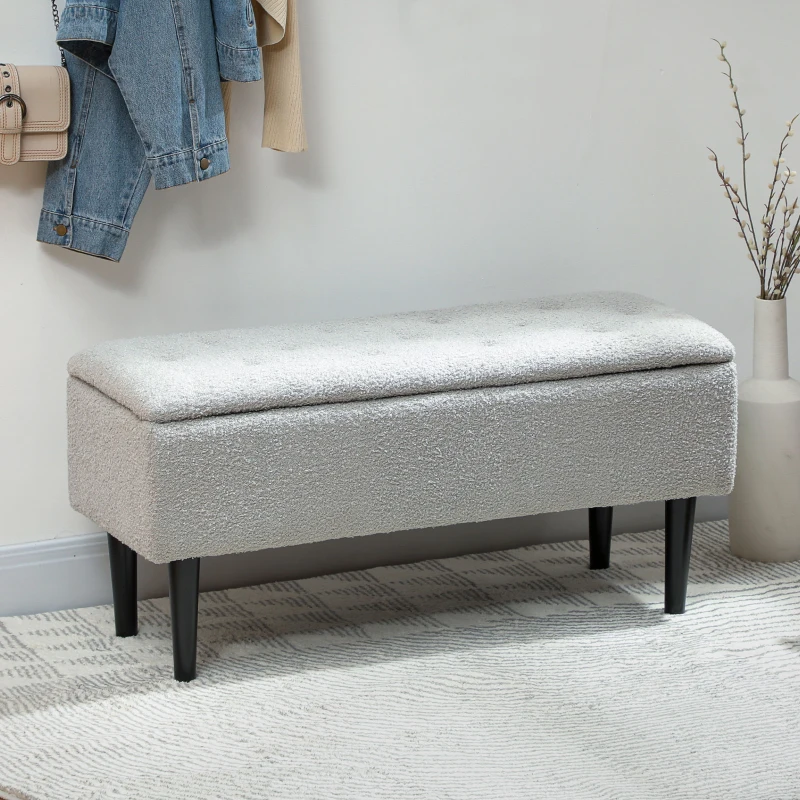 Grey lamb’s wool storage bench in hallway with coat rack