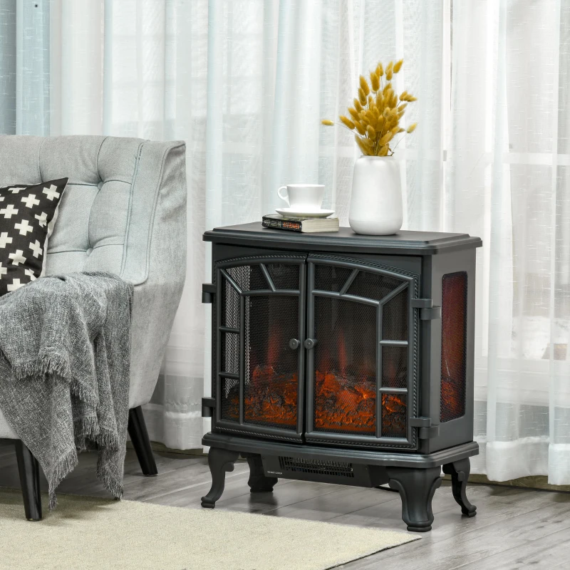 Compact black electric fireplace stove beside gray armchair.