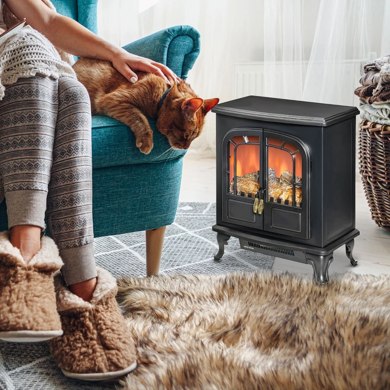 Vintage double-door black electric fireplace stove near gray chair.