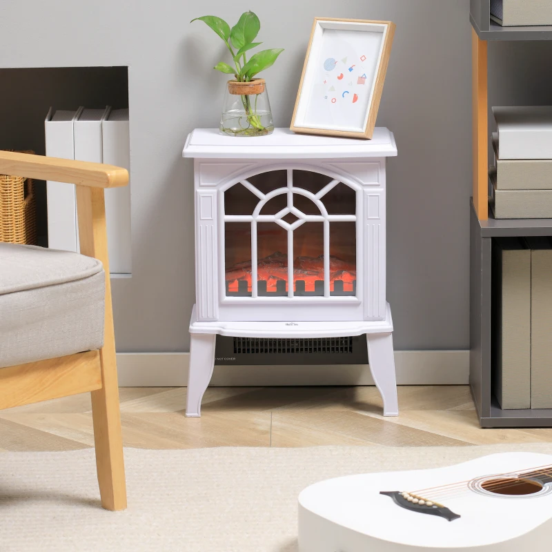 Small white freestanding electric fireplace beside chair and bookshelf.