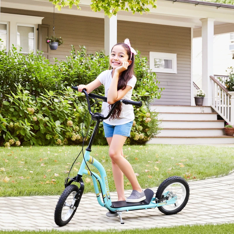 Young boy standing beside blue kick scooter near lake under clear sky.