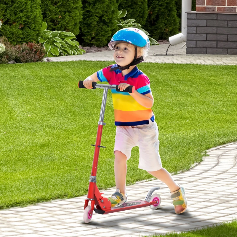 Young boy standing proudly with light blue scooter near lakeside homes.