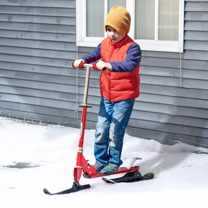 Young boy riding red snow scooter on snowy ground outside home.